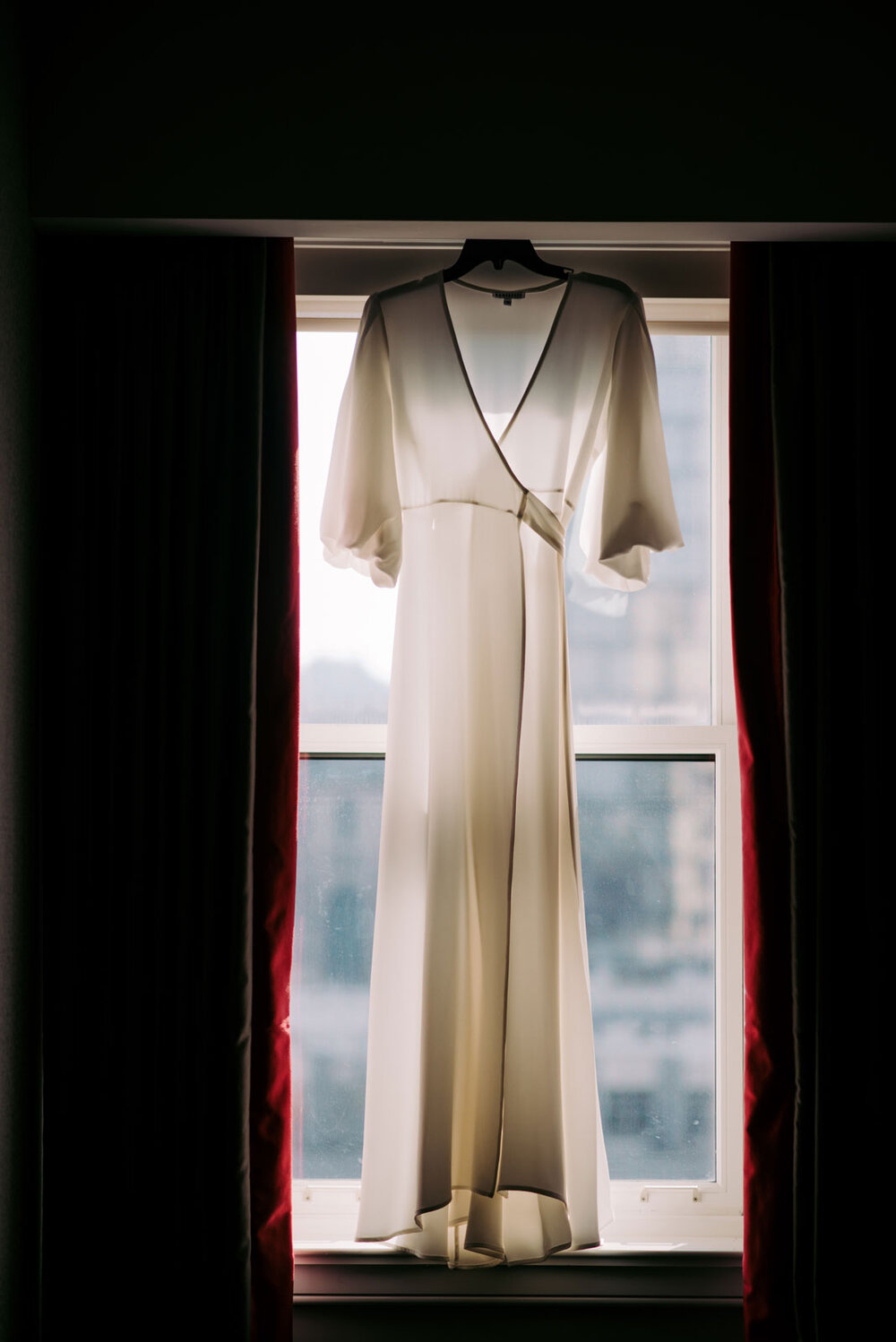 Wedding dress hanging in window at Pittsburgh Opera Pennsylvania Carly Romeo photography