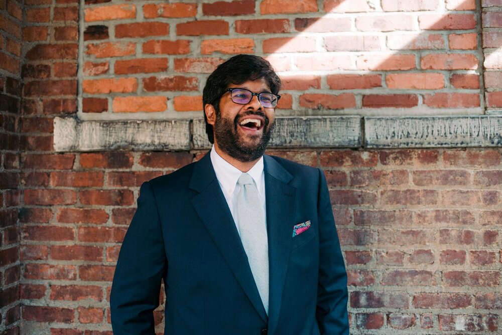 Groom in front of brick wall in Pittsburgh Pennsylvania Carly Romeo and Co.