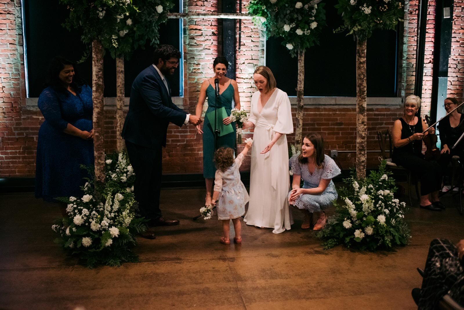 Flower girl offering petals to bride during wedding in Pittsburgh Opera PA Carly Romeo