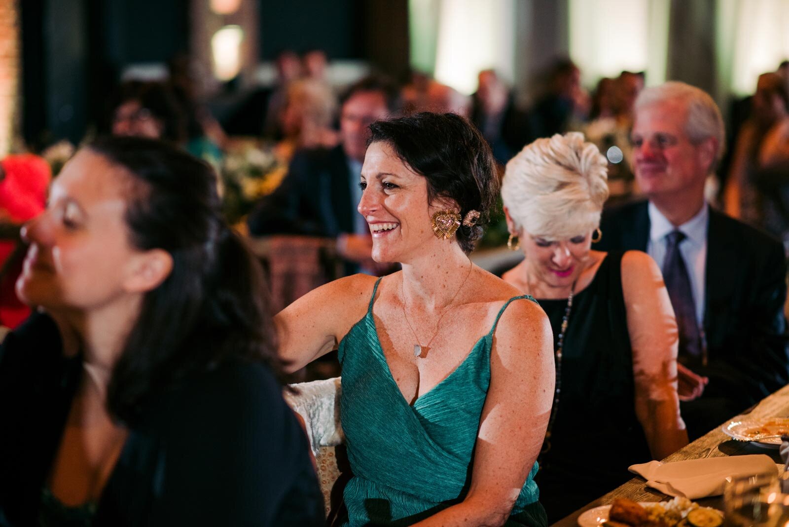 Wedding guest in teal dress smiling at reception in Pittsburgh Opera PA Carly Romeo + Co