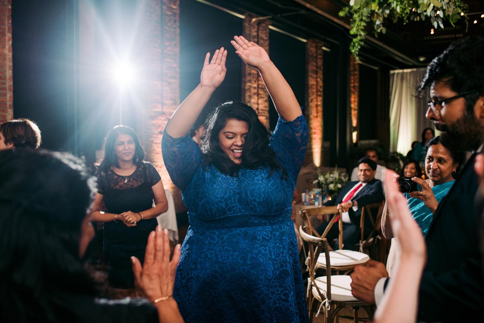 Woman of color in blue lace dress dancing at Pittsburgh Opera wedding reception Pennsylvania Carly Romeo