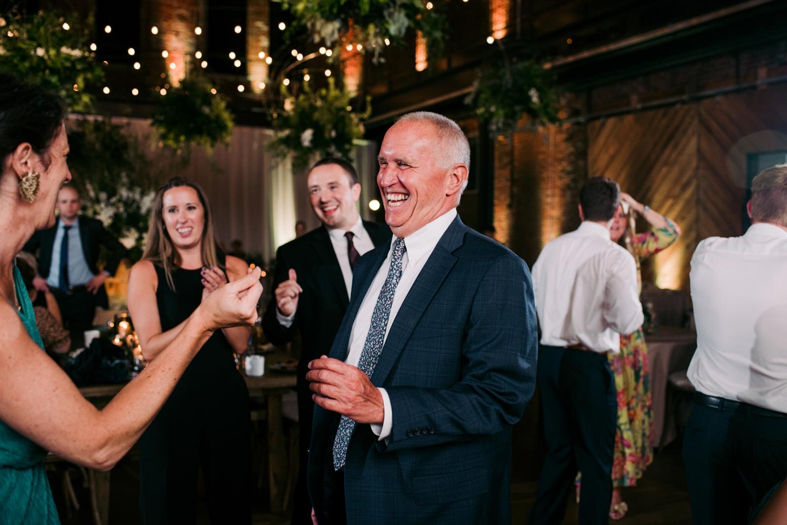 Grey haired man smiling and dancing at wedding celebration in Pittsburgh Opera PA Carly Romeo &amp; Co.