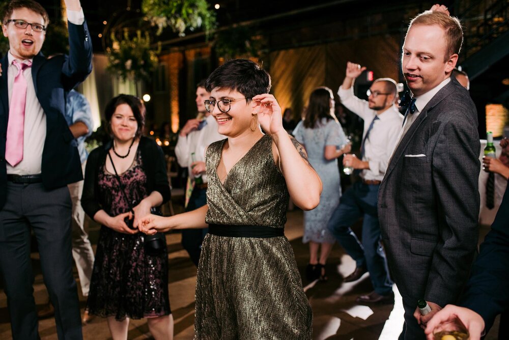 Woman in metallic dress dancing with guests at reception in Pittsburgh Opera PA Carly Romeo