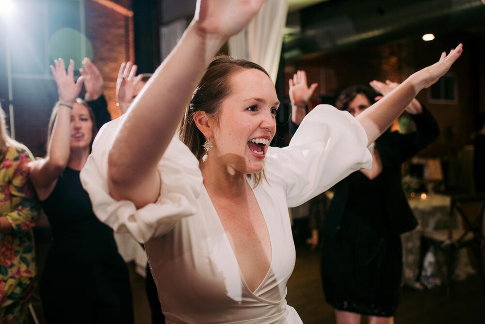 Newlywed bride dancing with her arms in the air at reception in Pittsburgh Opera PA Carly Romeo