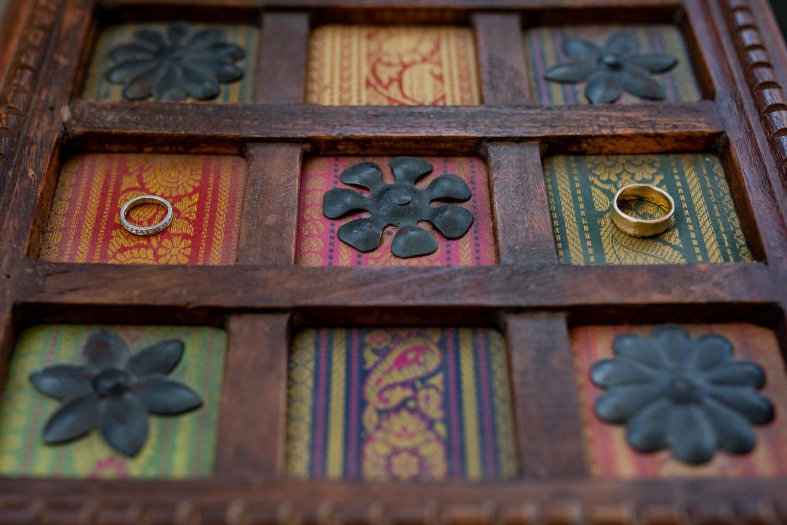 Two wedding rings on colorful decor wooden frame in Mendocino California Carly Romeo