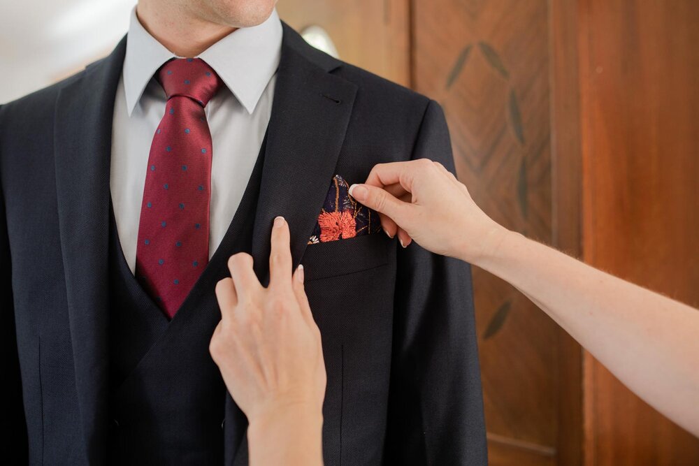 Bride adjusting groom's pocket handkerchief in Mendocino CA Carly Romeo &amp; Co .