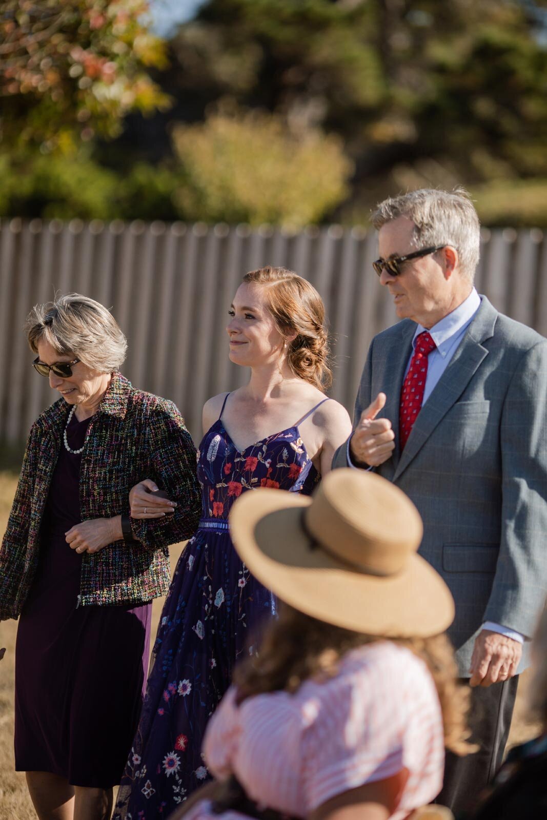 Bride walking to wedding ceremony with both parents in Mendocino CA Carly Romeo photography