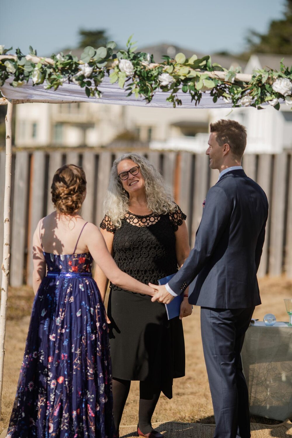 Bride and groom with officiant under Chuppah in Mendocino backyard California Carly Romeo and Co