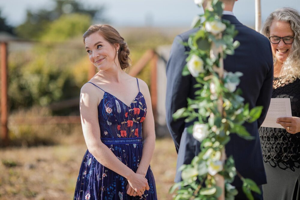 Bride looking playfully at family during wedding ceremony in backyard Mendocino California Carly Romeo &amp; Co.