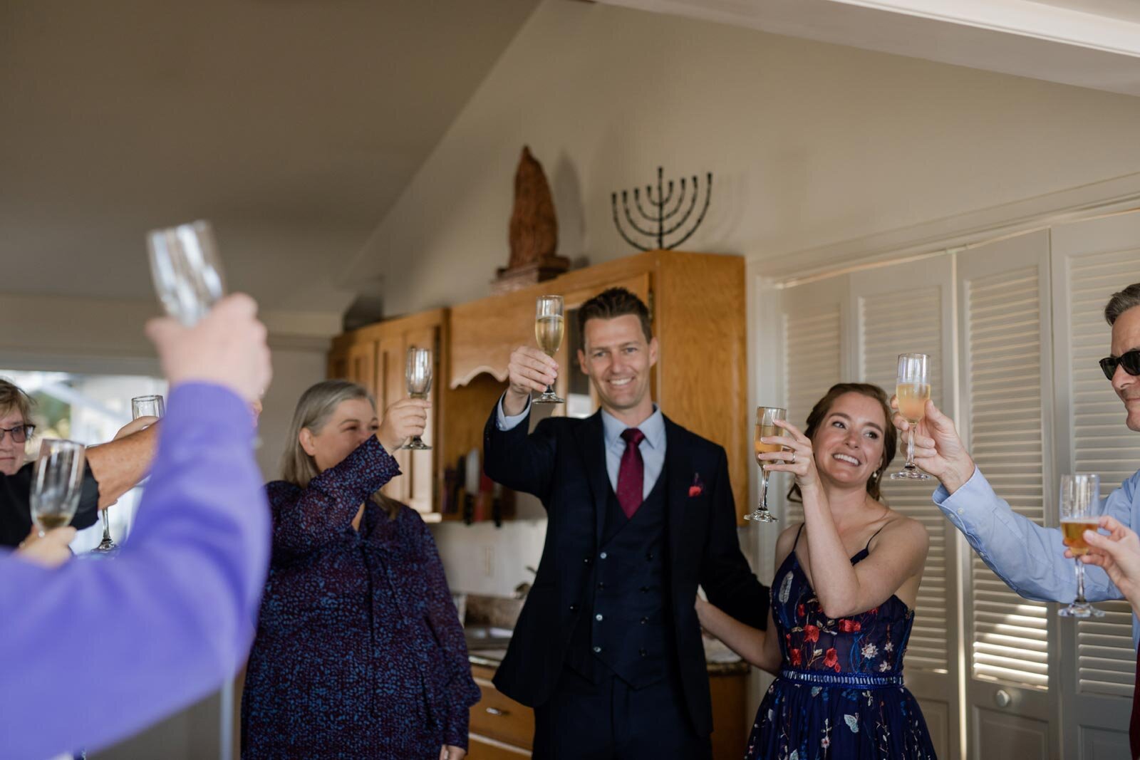 Bride and groom with wedding guests raising glasses of champagne in Mendocino CA Carly Romeo and Co.