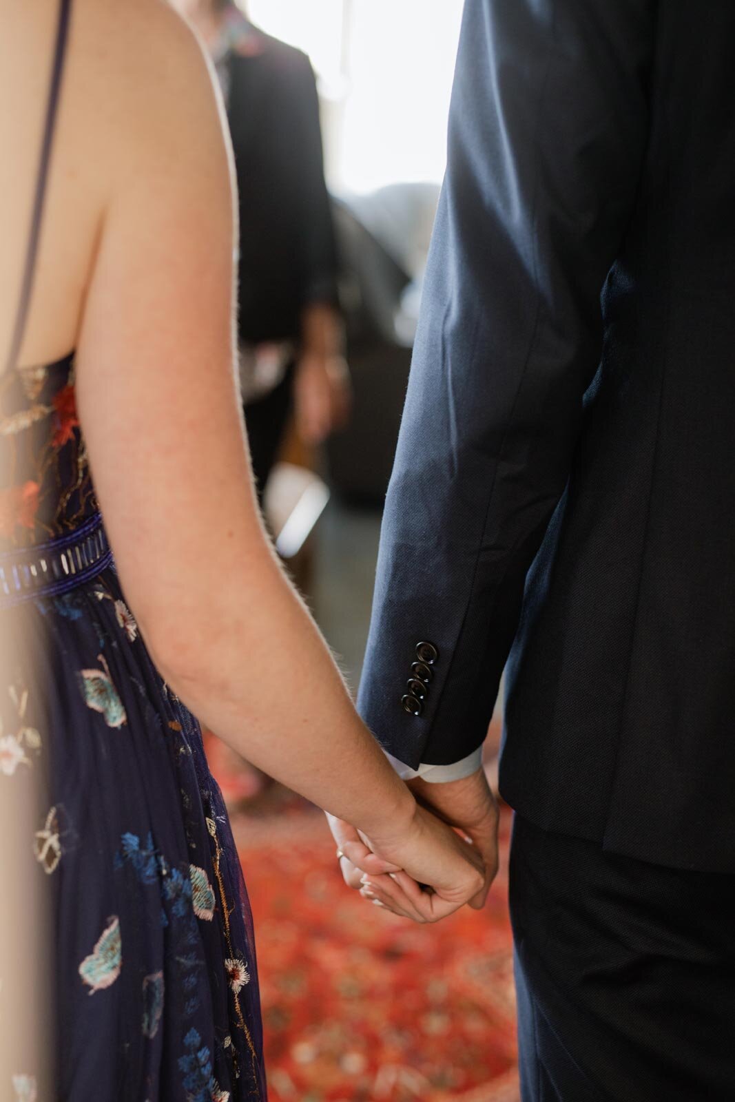 Close up of bride and groom holding hands after ceremony in Mendocino CA Carly Romeo