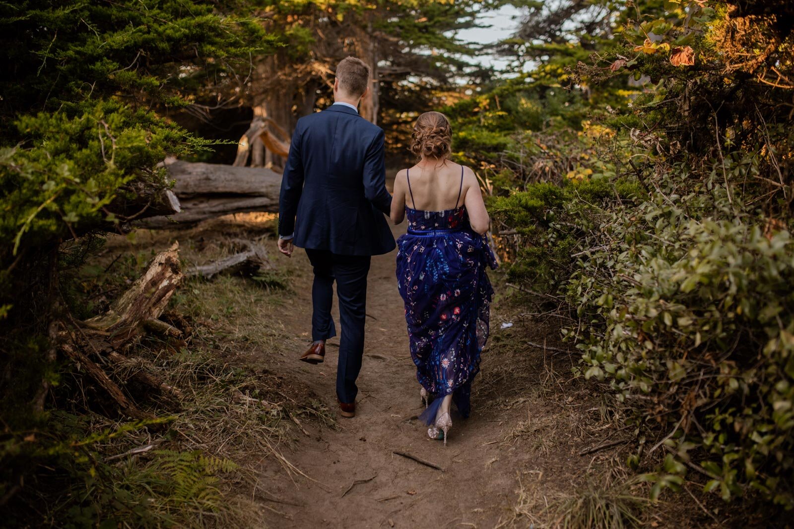 Bride in blue embroidered dress with groom walking through west coast woodland in Mendocino CA Carly Romeo