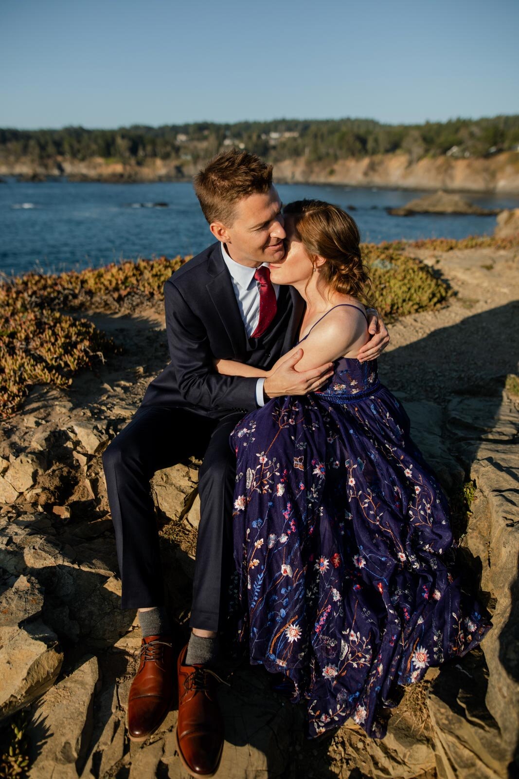 Bride and groom embracing on a cliffside overlooking the ocean in Mendocino CA Carly Romeo wedding photography