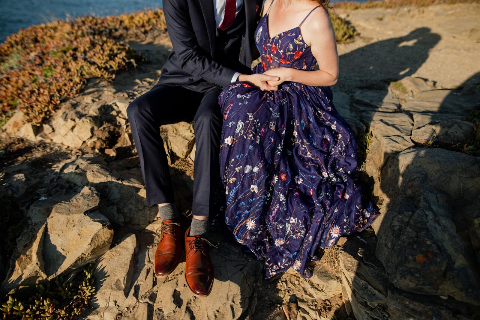 Bride in nontraditional blue wedding dress embracing groom on a cliffside in Mendocino California Carly Romeo