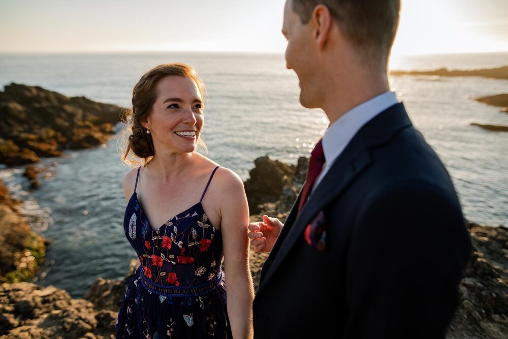 Bride and groom smiling at each other on oceanside cliff in Mendocino CA Carly Romeo and Co