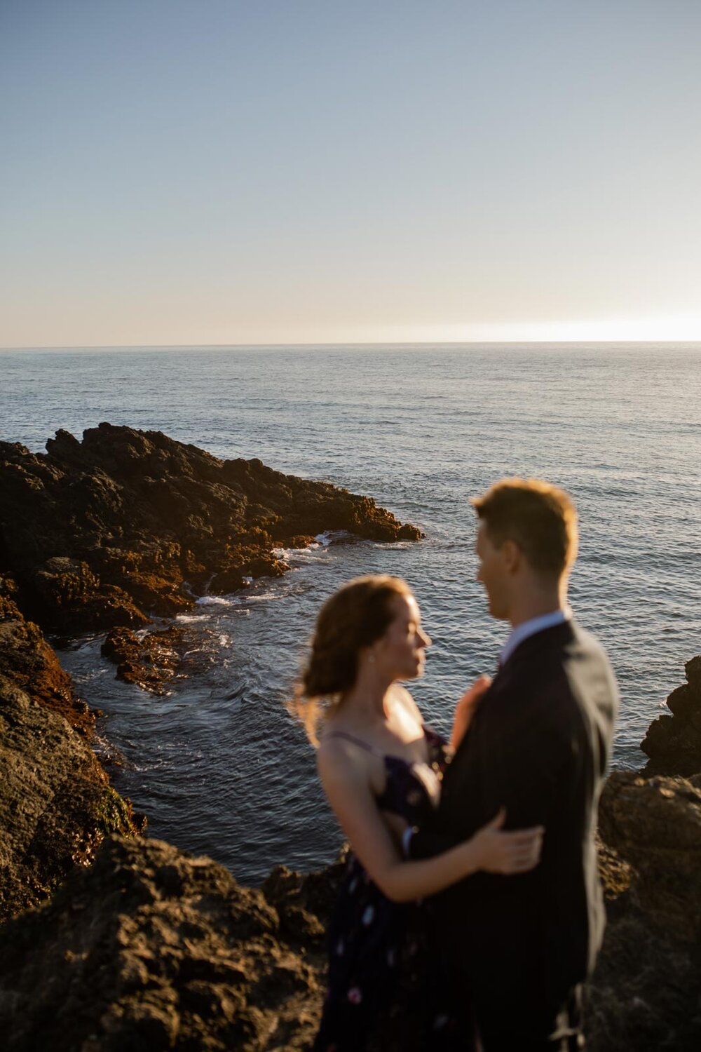 Newlywed couple on oceanside rocky cliff at sunset in Mendocino CA Carly Romeo photography
