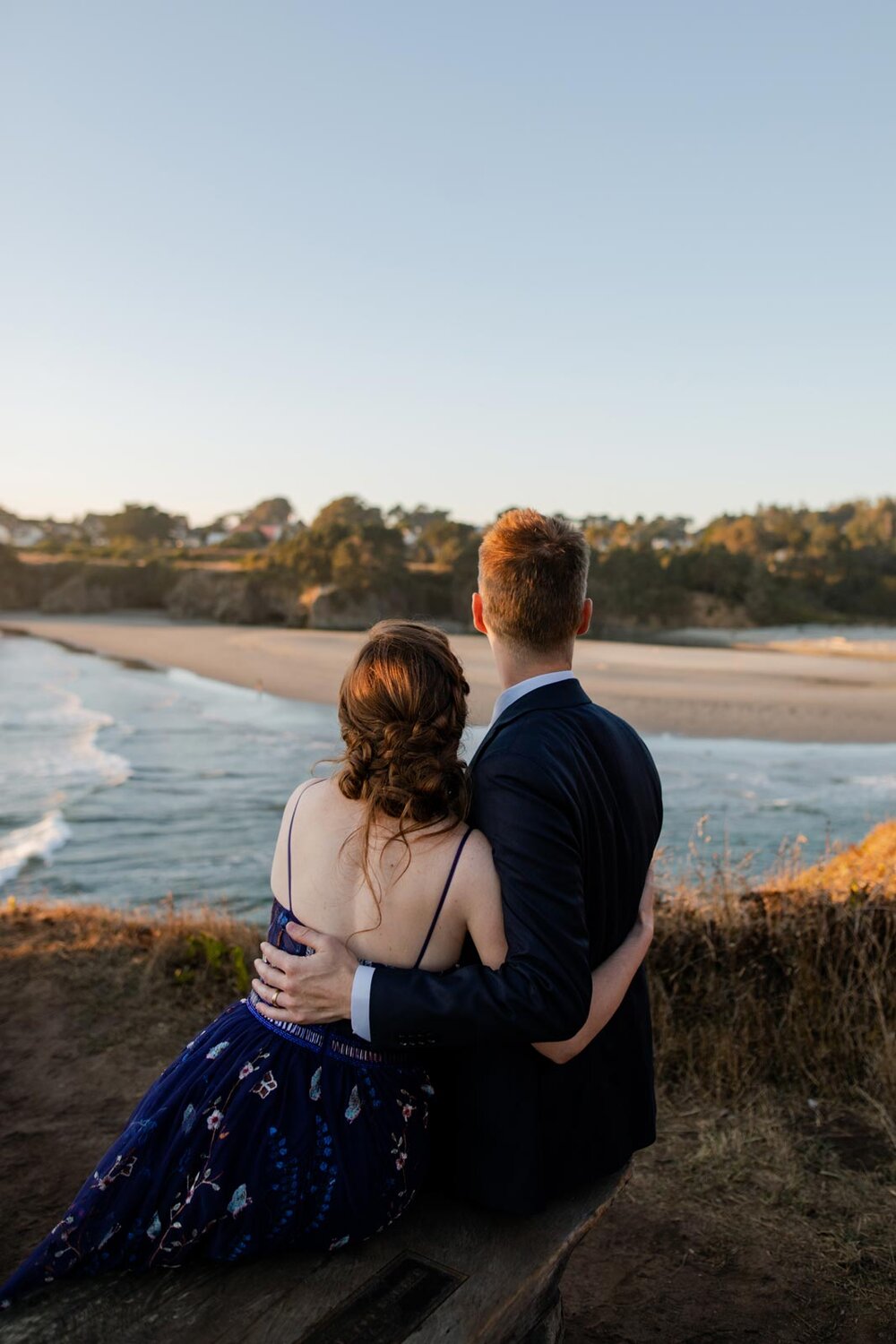 Newlywed partners looking away over the ocean in Mendocino CA Carly Romeo &amp; Co