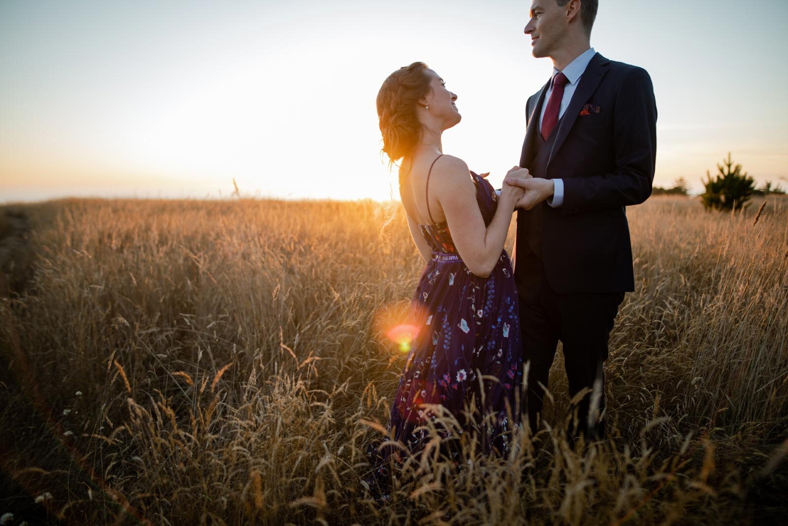 Newlywed couple holding hands in a grassy field at sunset in Mendocino California Carly Romeo