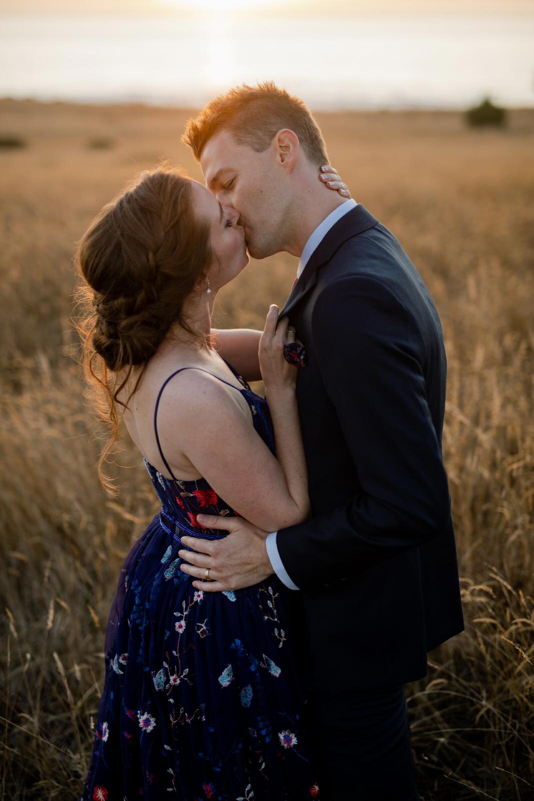 Newlywed bride and groom kissing in a grassy field at sunset in Mendocino CA Carly Romeo photography