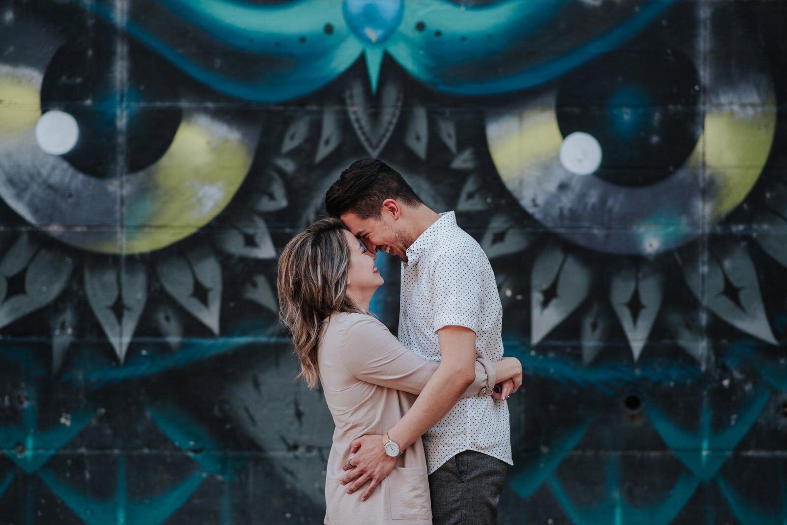 Couple embracing and smiling before a blue black and yellow mural in RVA Carly Romeo &amp; Co. (Copy)