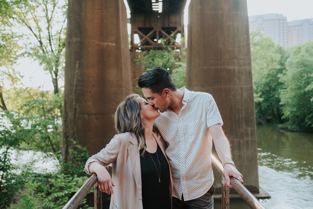 Engaged couple kissing on a bridge over the James River in Richmond VA Carly Romeo &amp; Co. (Copy)