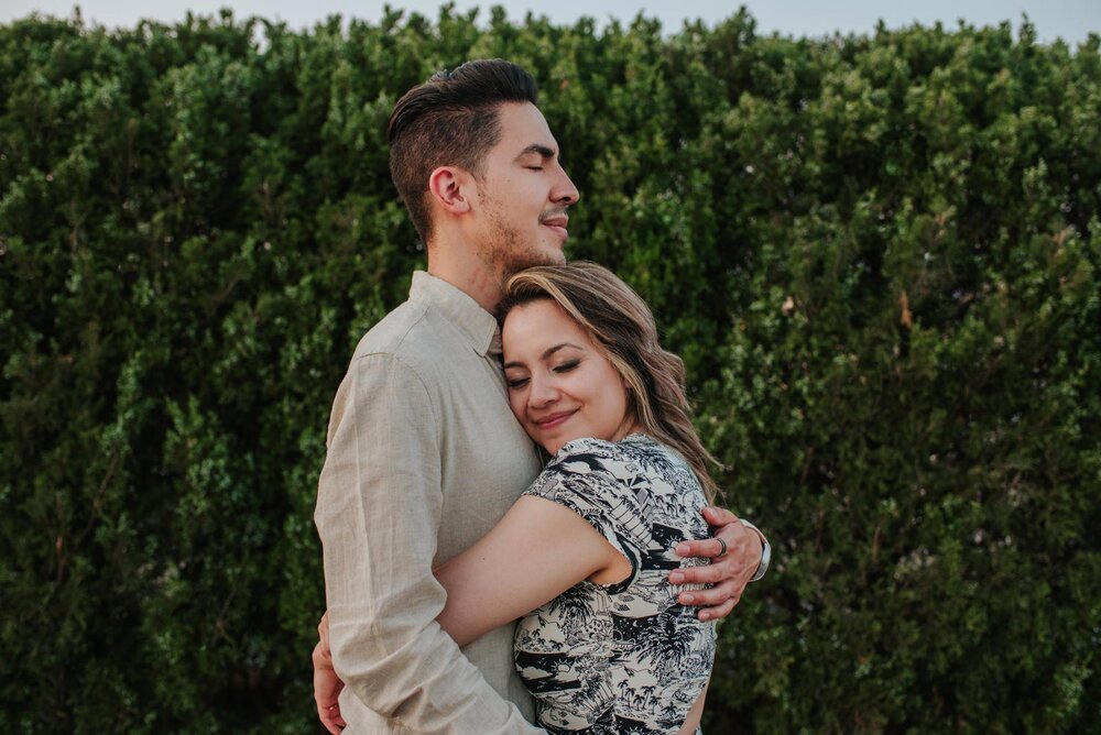 Spouses embracing with their eyes closed before greenery in Richmond VA Carly Romeo &amp; Co. (Copy)