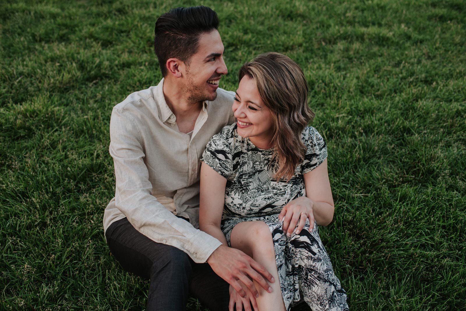Betrothed couple sitting together in lush grass field in Richmond VA Carly Romeo and Co. (Copy)