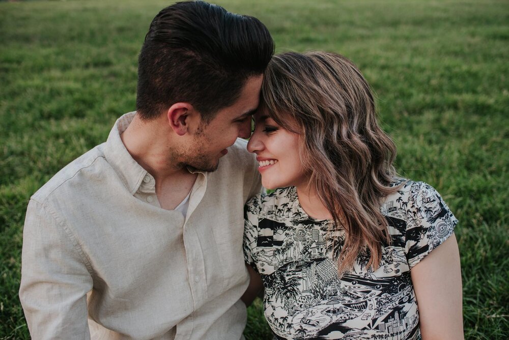 Latinx couple pressing their foreheads together on grassy field in RVA Carly Romeo (Copy)