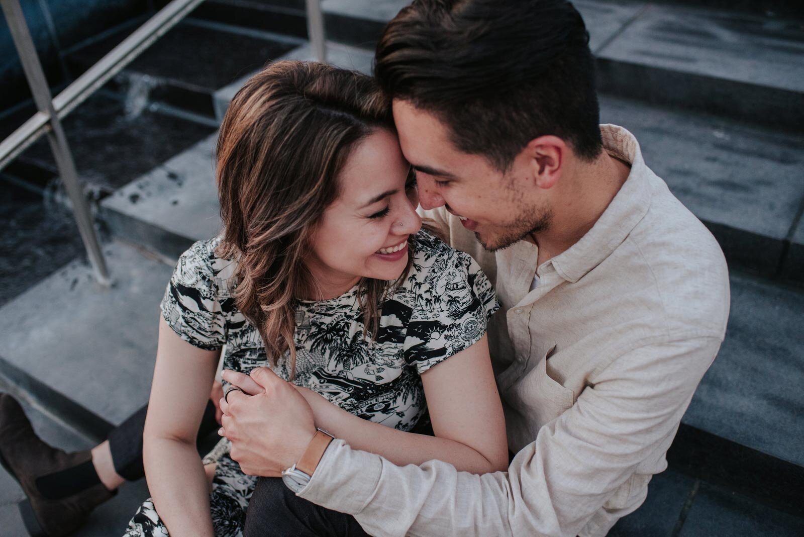 Engaged couple embracing while sitting on the stairs outside the VMFA in RVA Carly Romeo &amp; Co. (Copy)