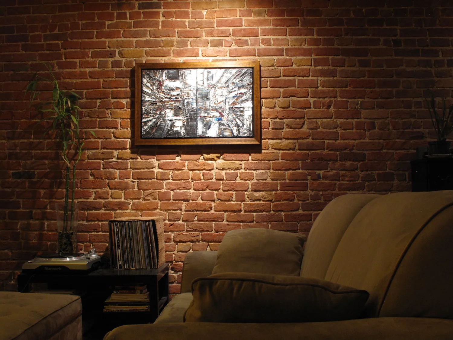 Or Noir artwork framed on a brick wall in living room