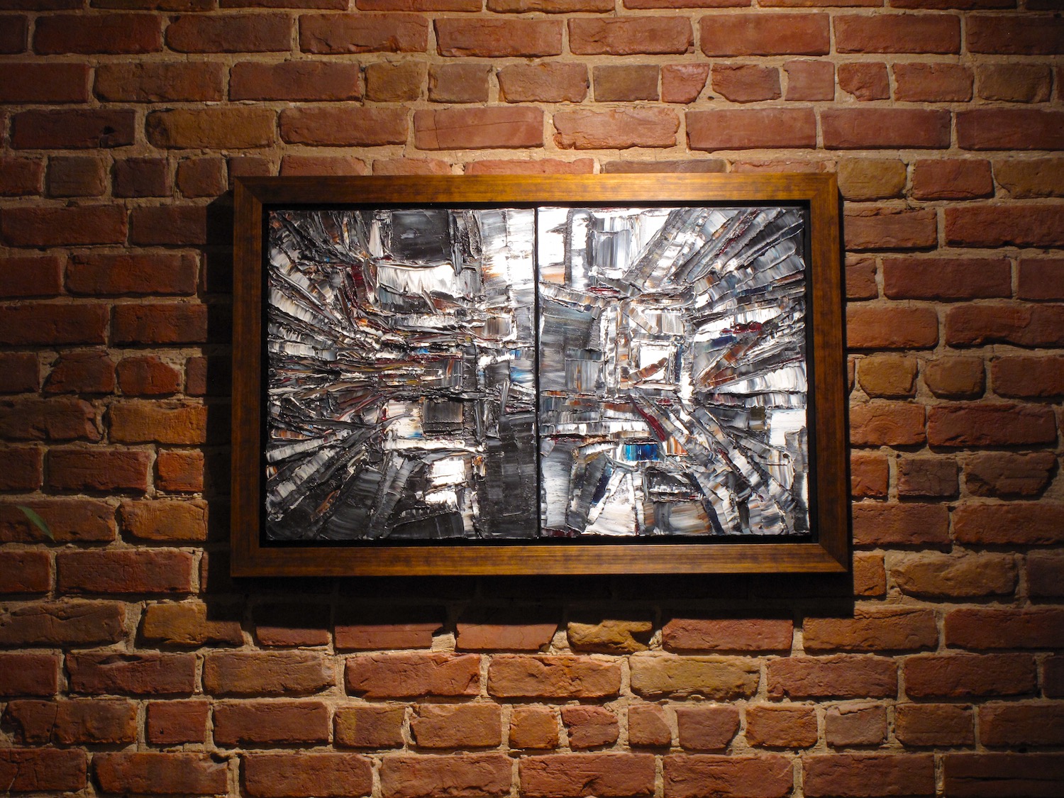 Tableau Or Noir encadré sur un mur de briques