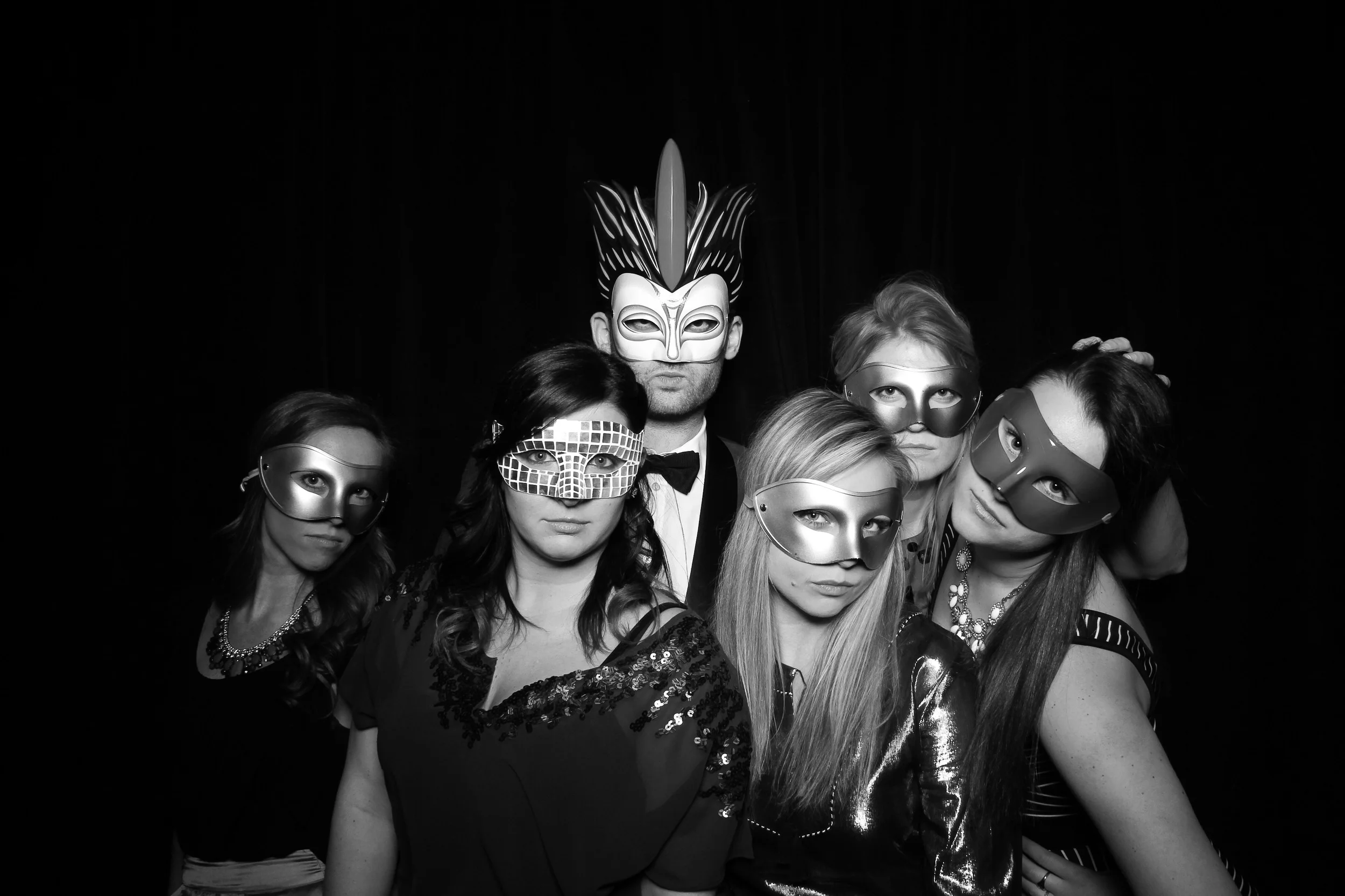 A group masquerade photo booth shot with the black draped velvet at Venue One.