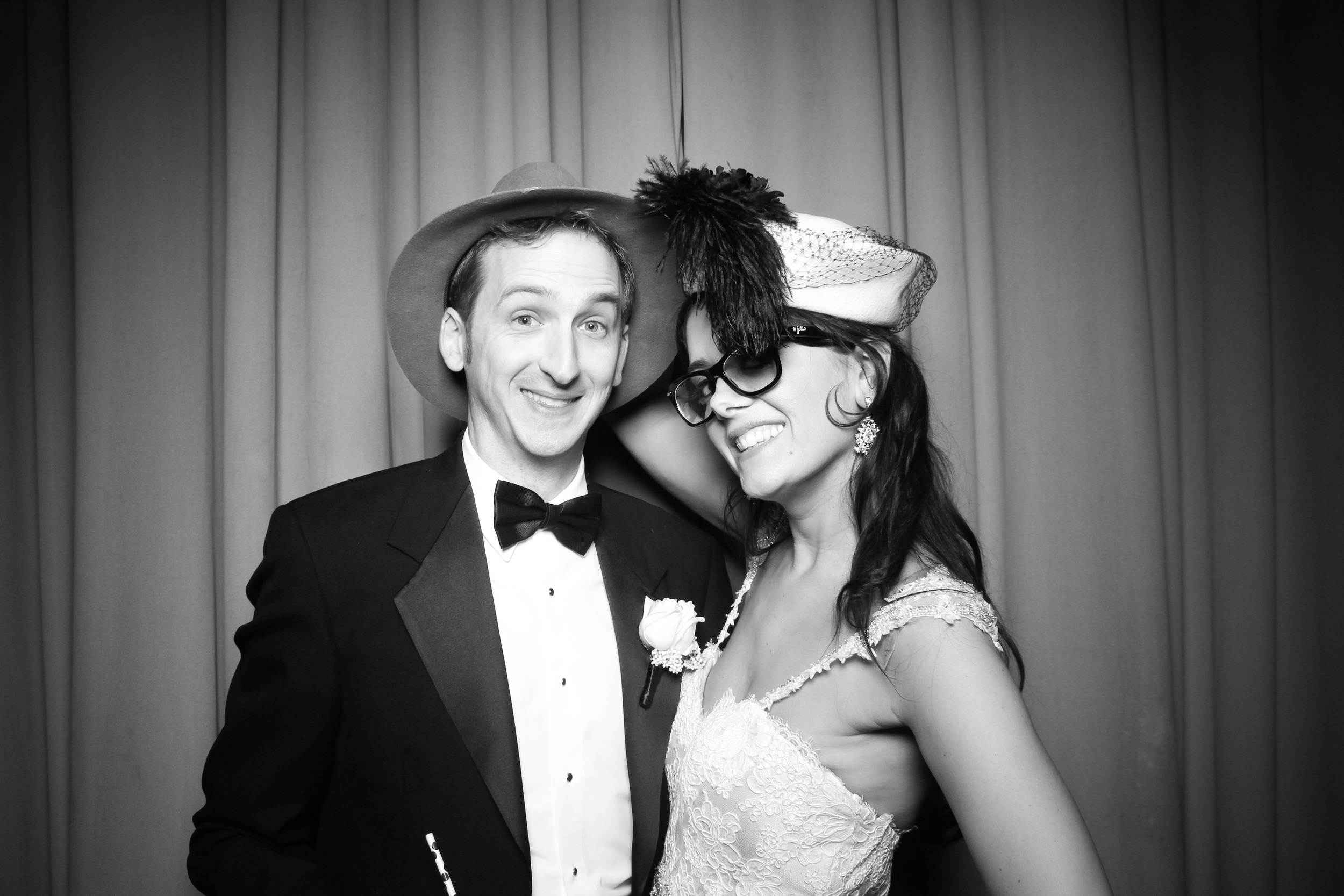 The bride and groom pose for a photo booth picture in Ruggles Hall.