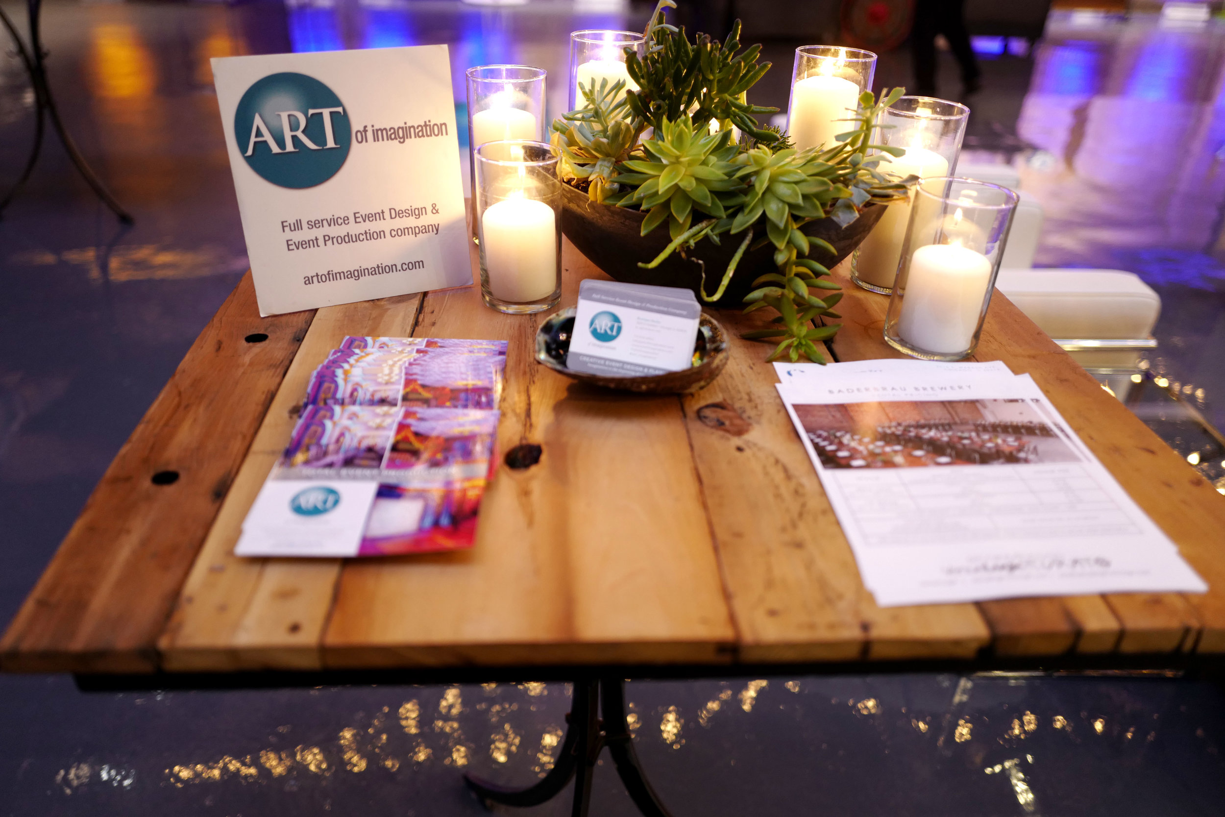 The Art of Imagination info table! LOVED the cafe lights and uplighting on the beer cans etc - they will transform your event!