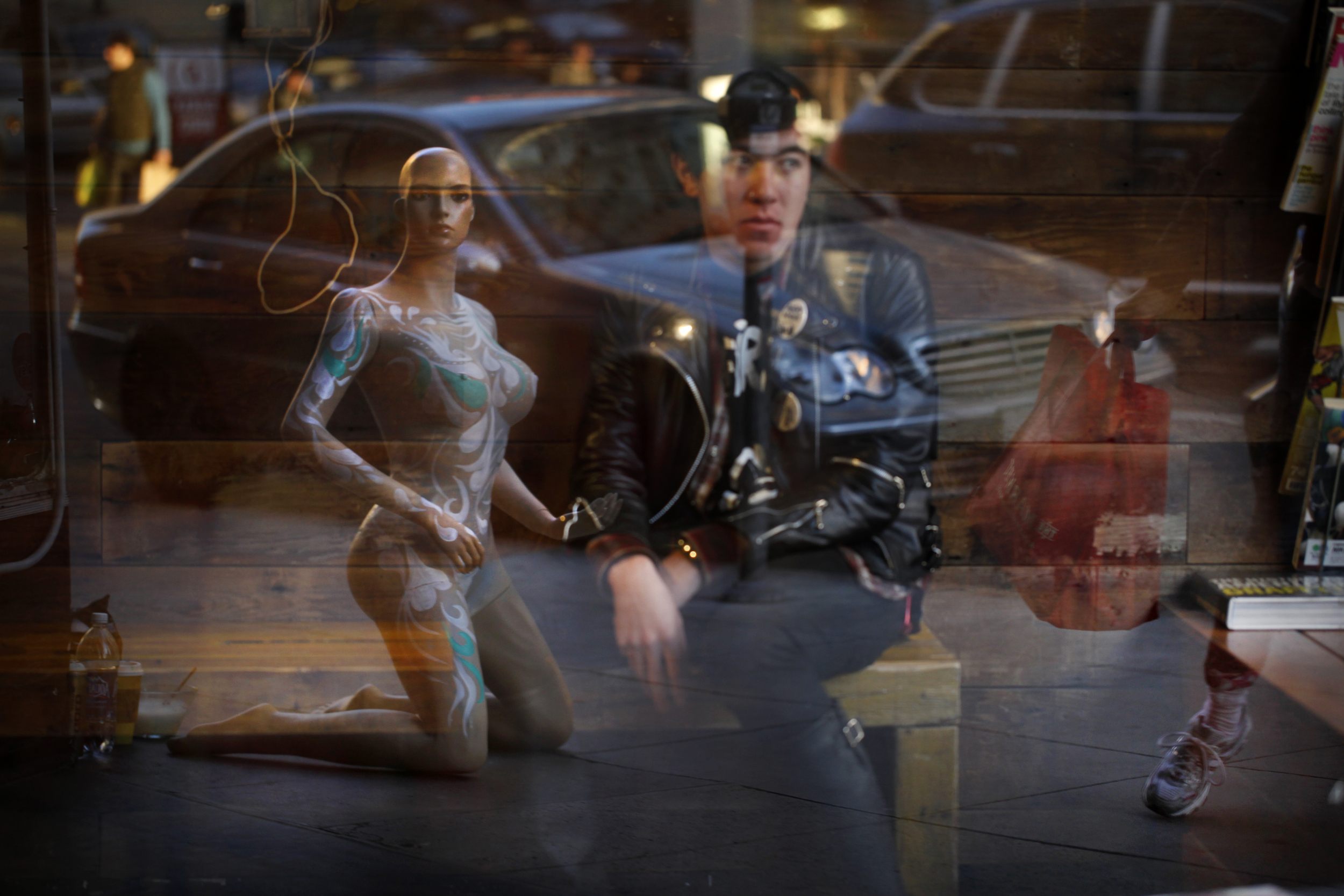  Waiting for a hair cut, Nathan Tan, of San Francisco, watches as artist Bethany Rose paints a mannequin on the sidewalk in front of Glass Kandi on Geary Street in San Francisco. &nbsp; 