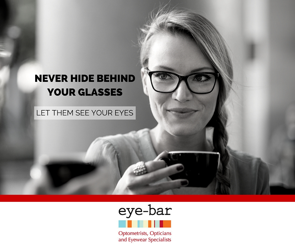 Lady drinking coffee wearing black framed eyeglasses with non-glare lenses. Text in image says: Never hide behind your glasses. Let them see your eyes.