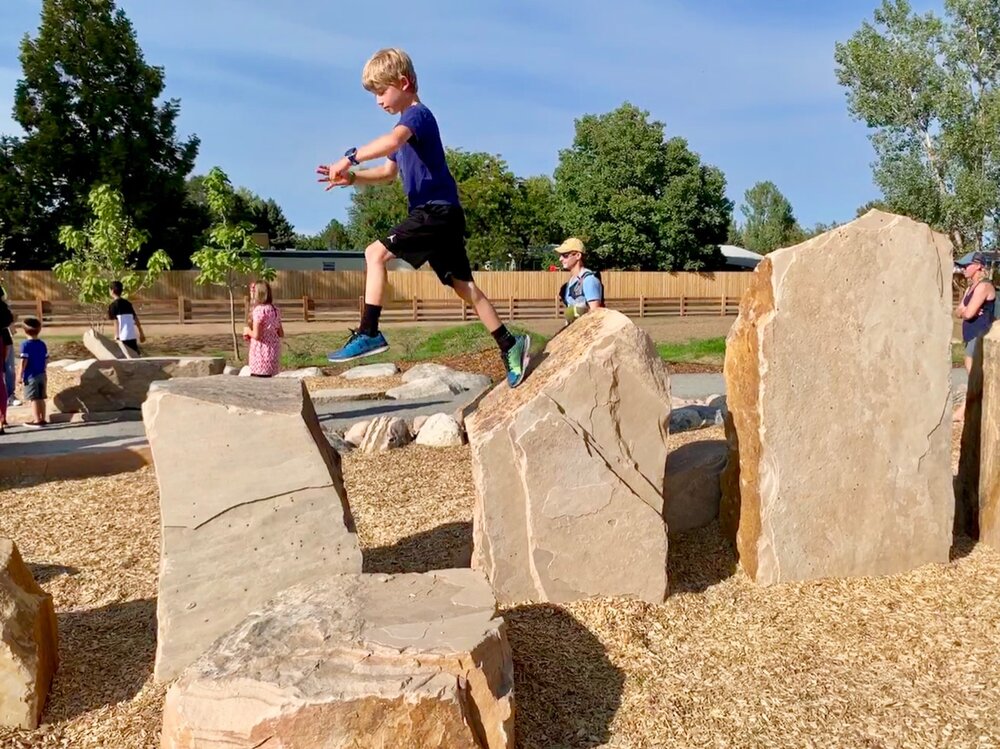  Kids jumping across boulders in the play area 