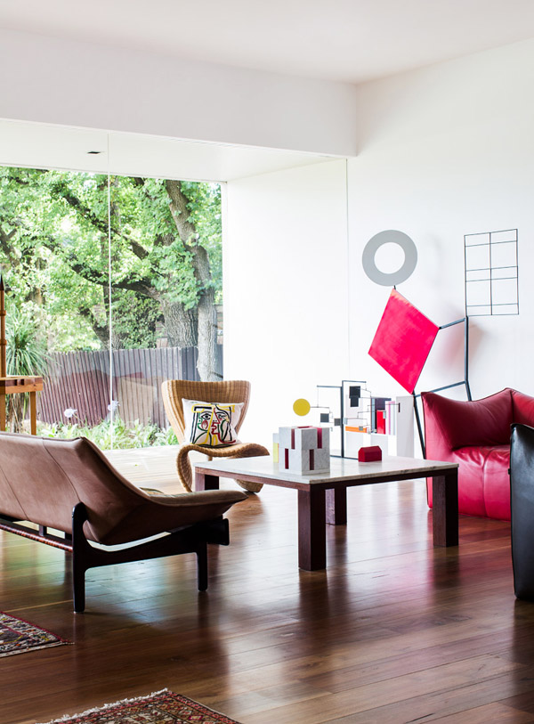 Living room. Timber sculpture at left – ‘Impossible Alliance’ , 1979 by Peter D Cole . Large sculpture with books – ‘Information’ , 2009 by Peter D Cole. Wicker chair by Marc Newson. Photo - Sean Fennessy , production – Lucy Feagins / The Design Files.