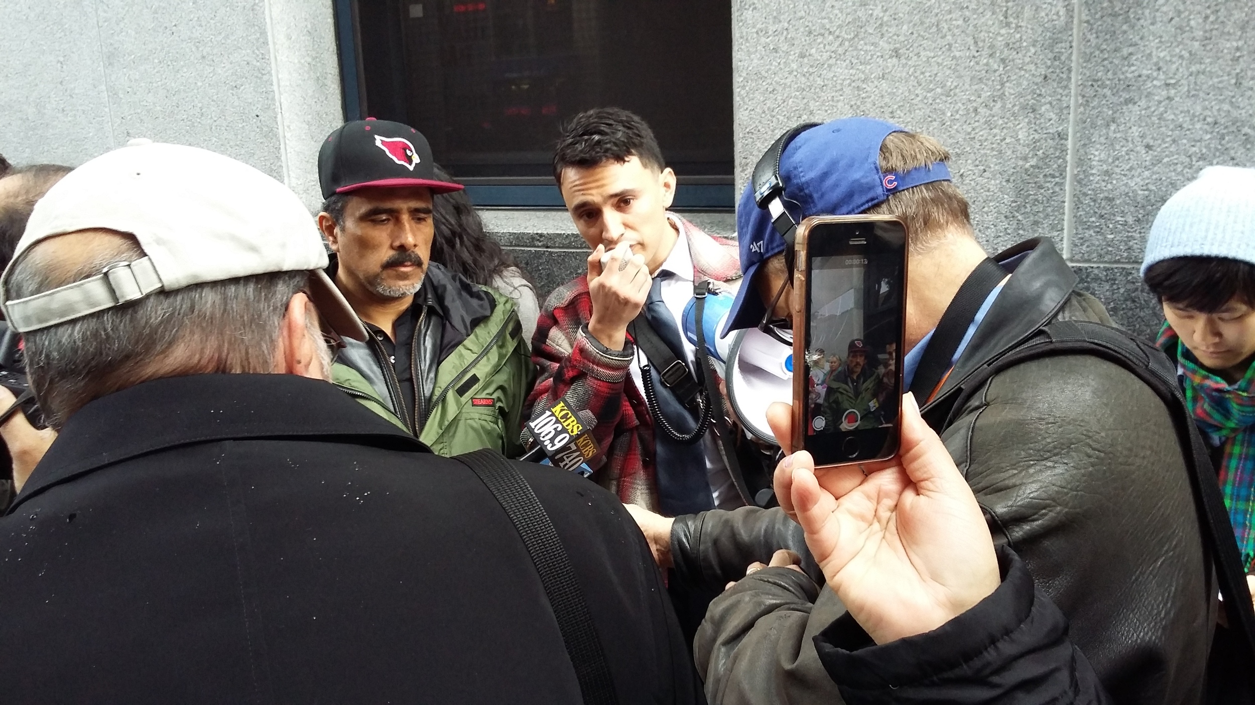 Ernesto on the left with attorney Luis Angel speaking at media action to educate community members about ICE raids (Jan. 2016). 