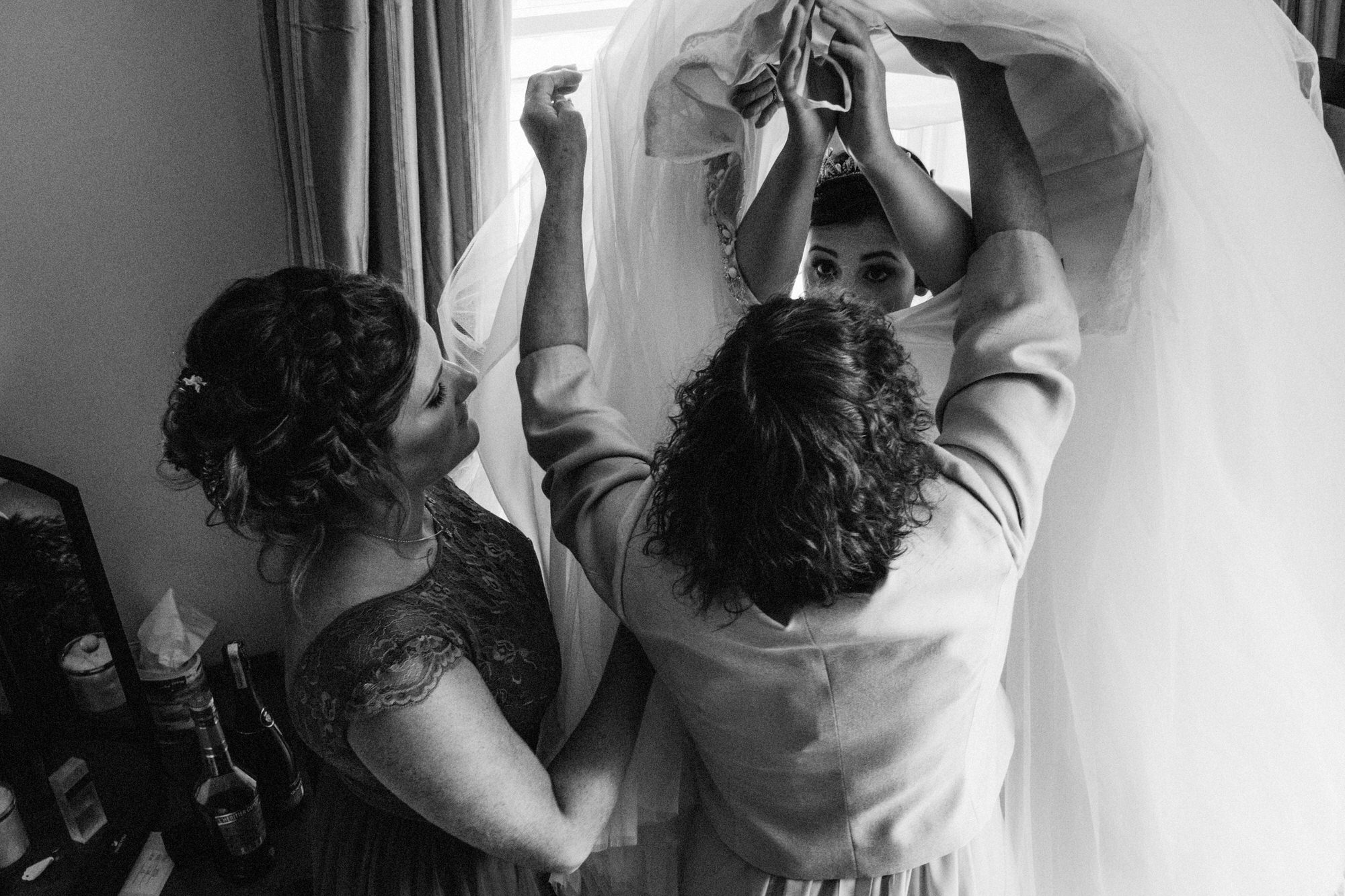 Bride getting helped into her dress