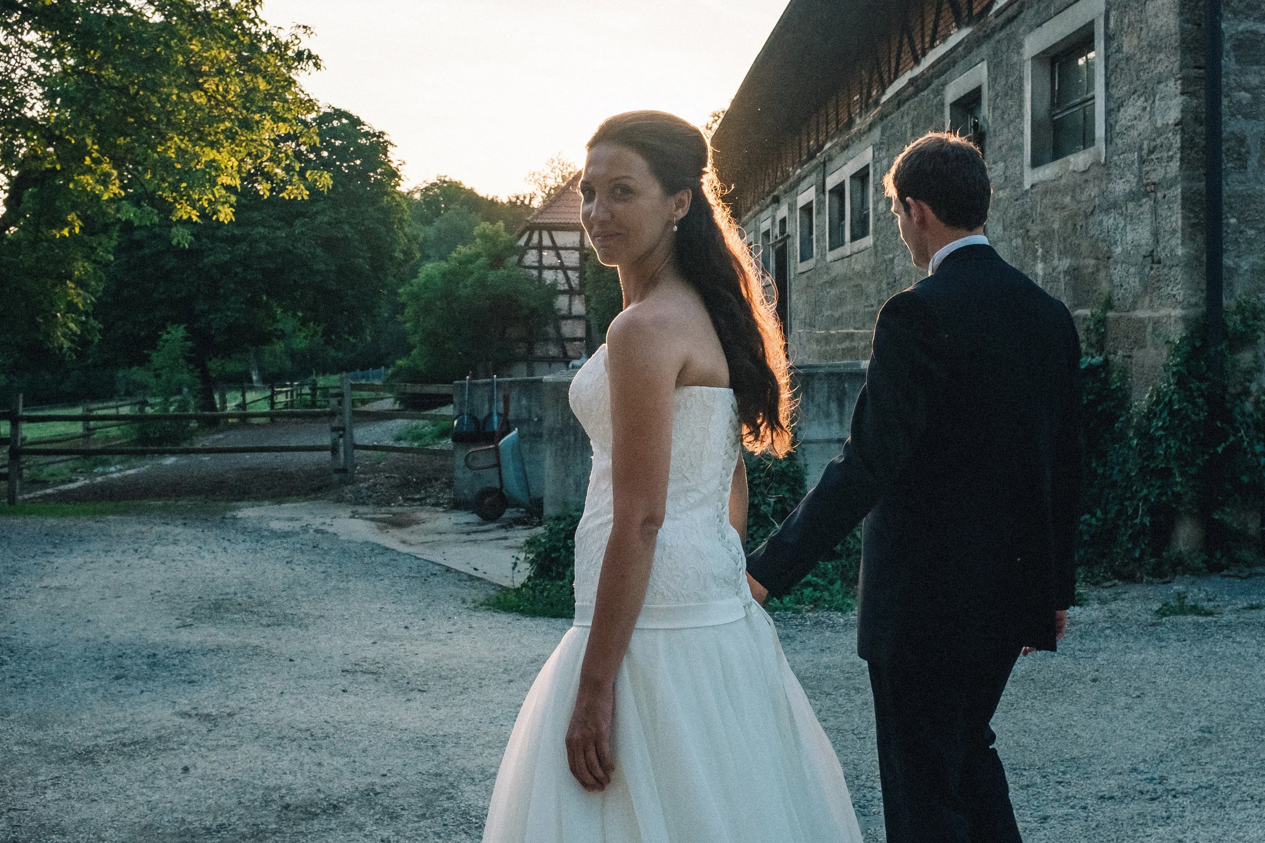 Groom and bride walking in the evening sunset