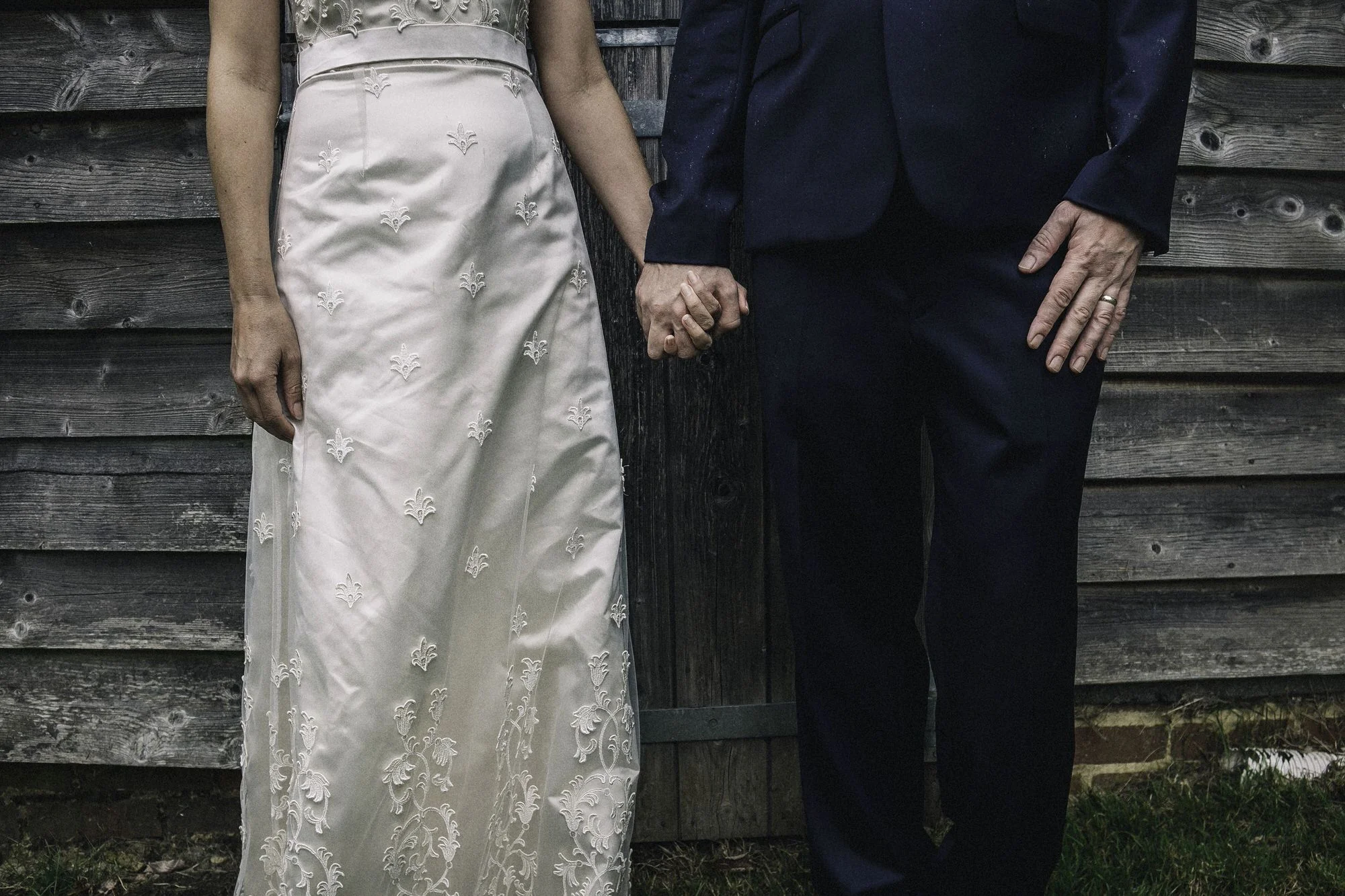 Hand holding bride + groom