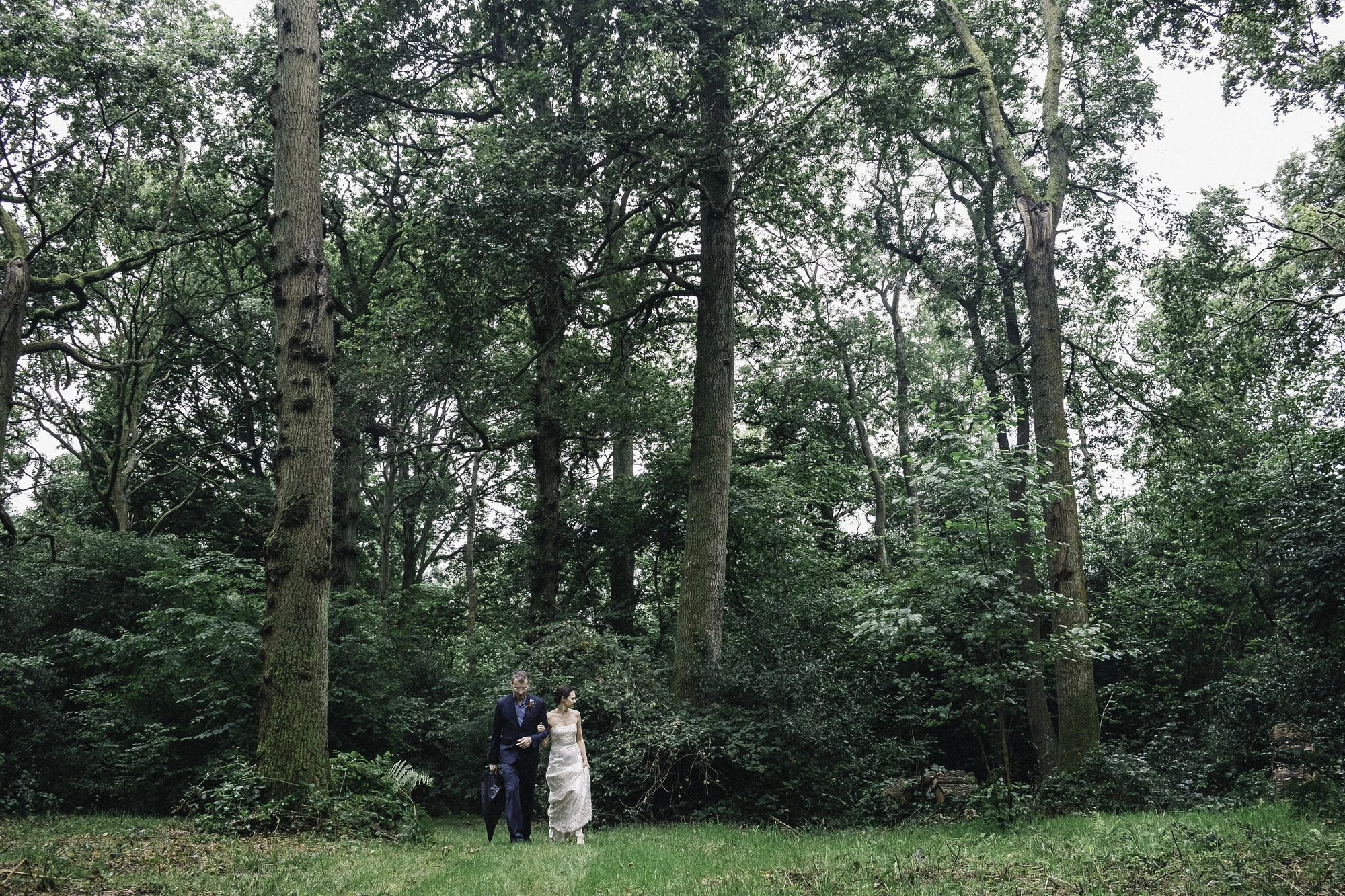 Bride + groom walking in forrest