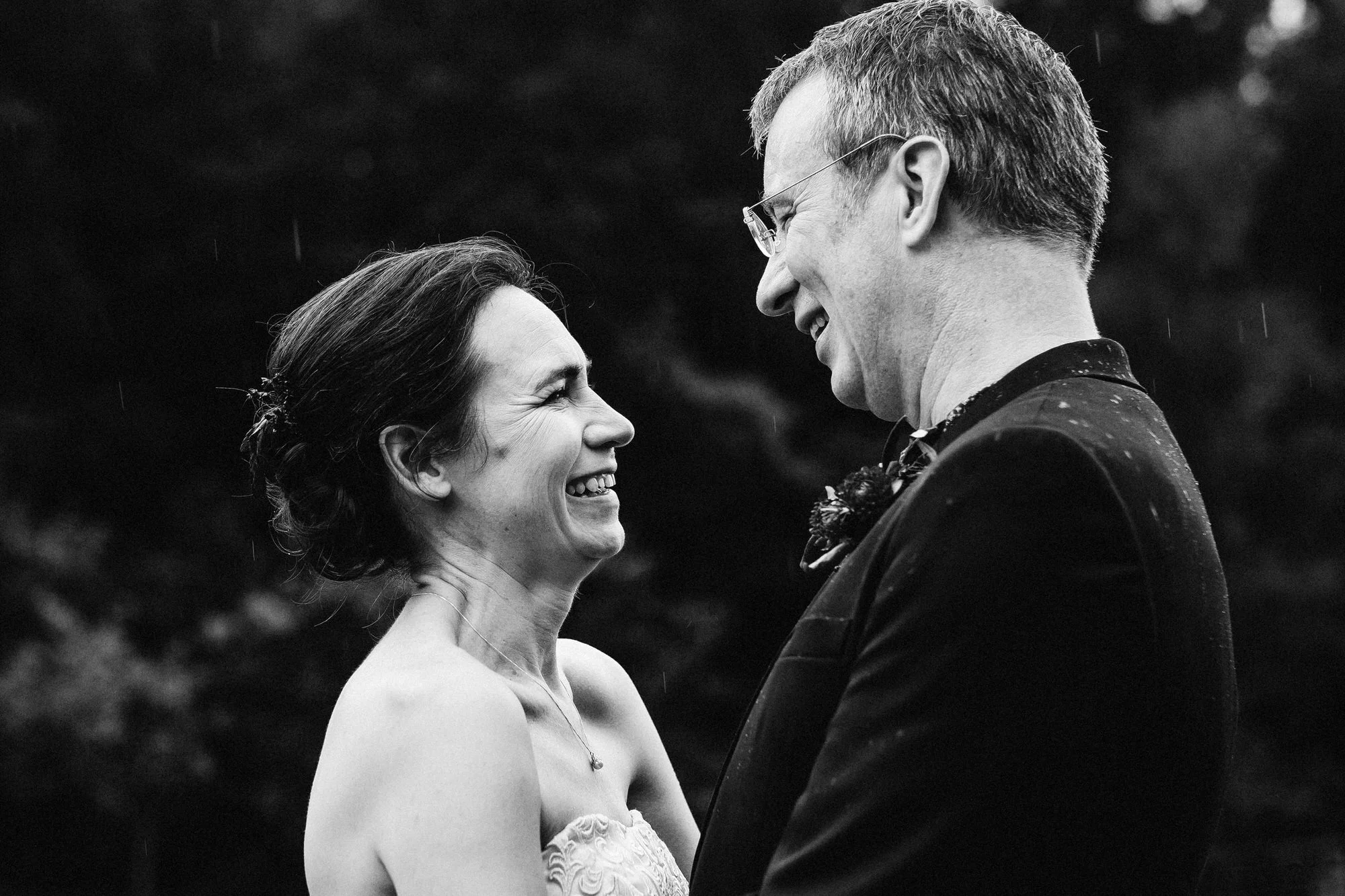 Bride + groom stand in the rain