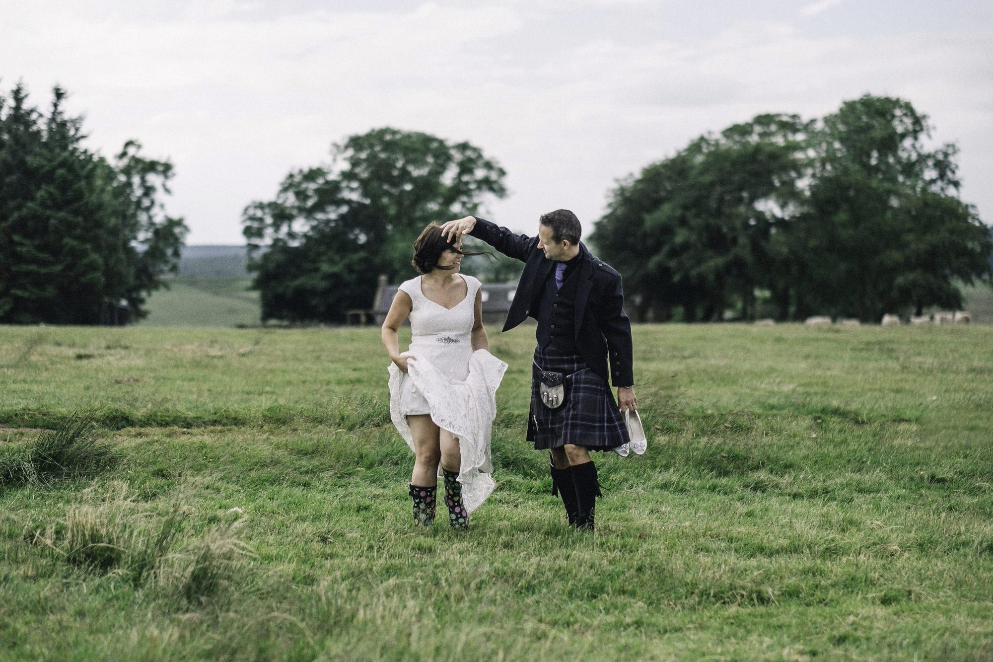 Bride & groom walking in a field