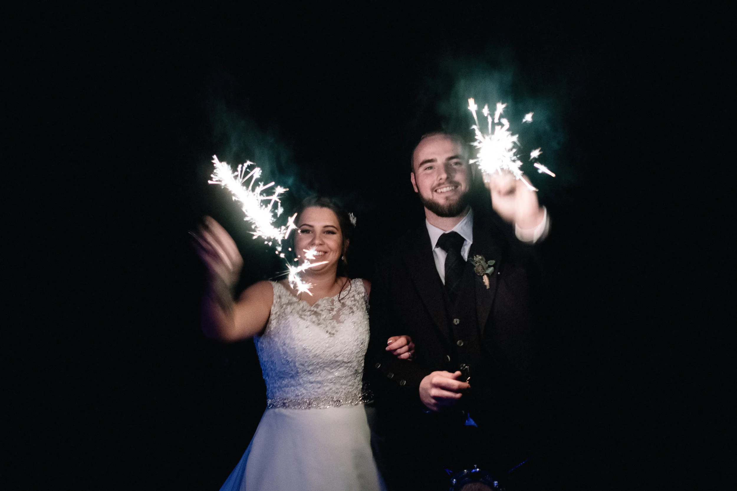 Bride and groom playing with sparklers