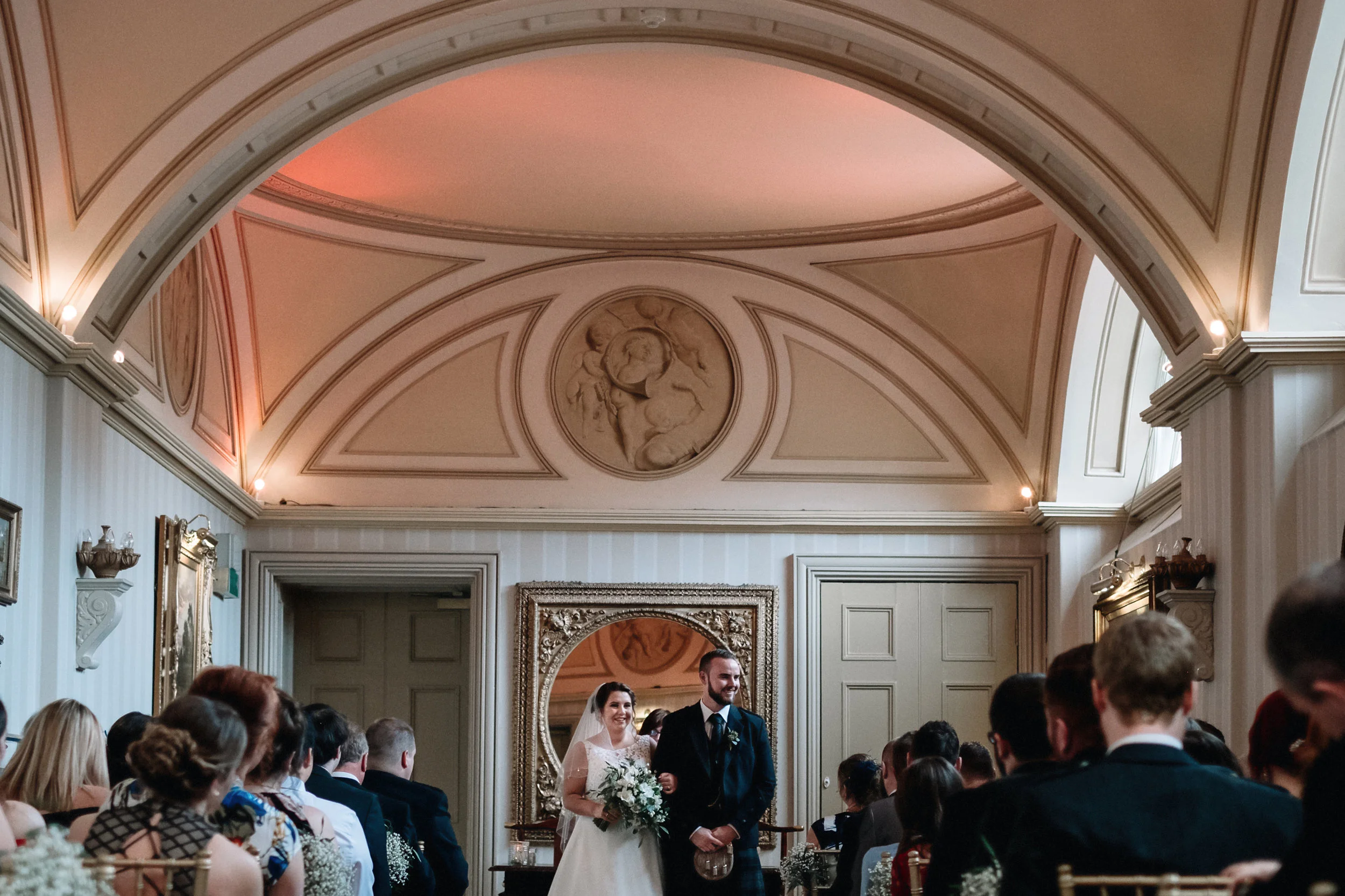 Bride and groom stand at the top of the aisle