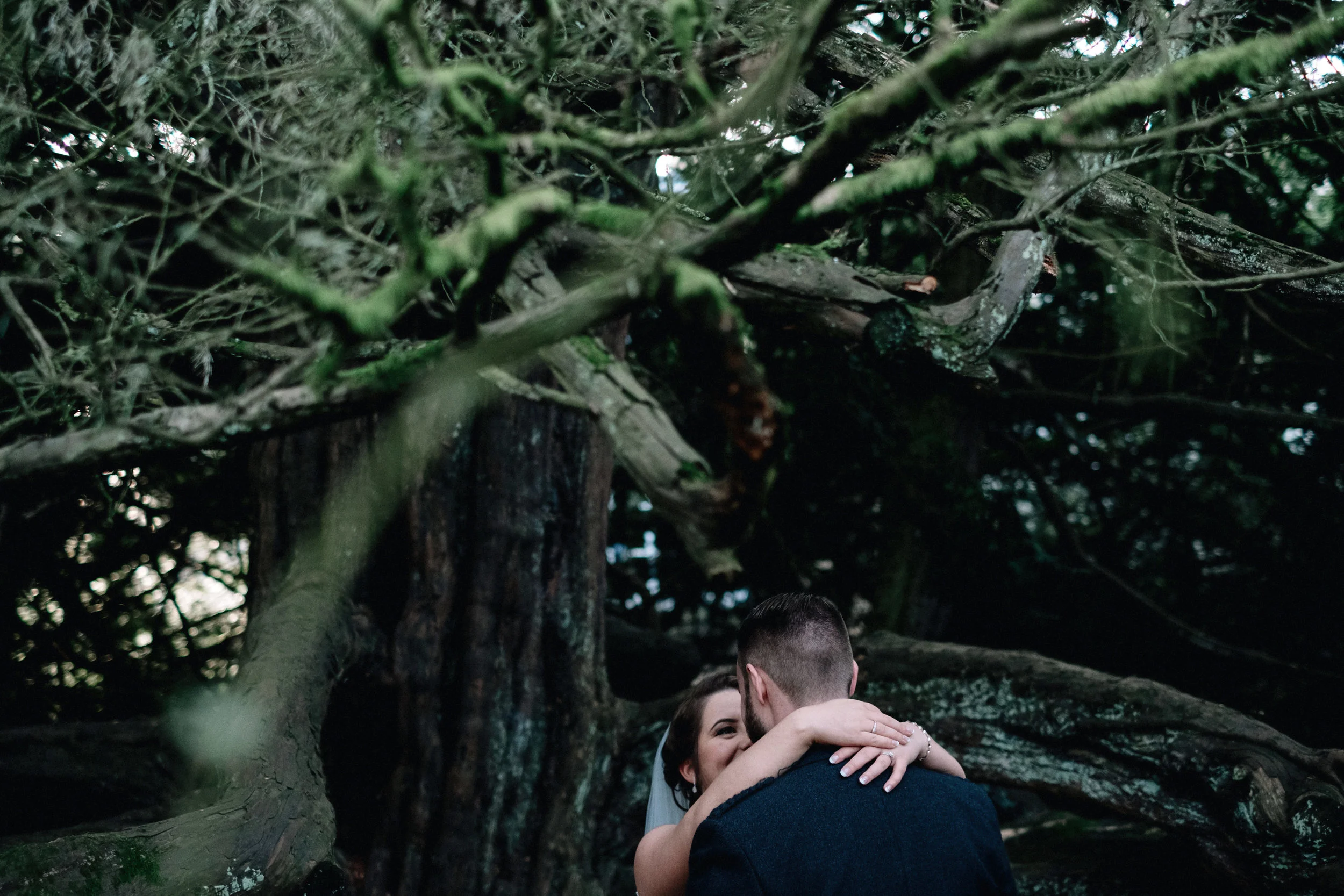 Bride and groom embrace in a Scottish forrest
