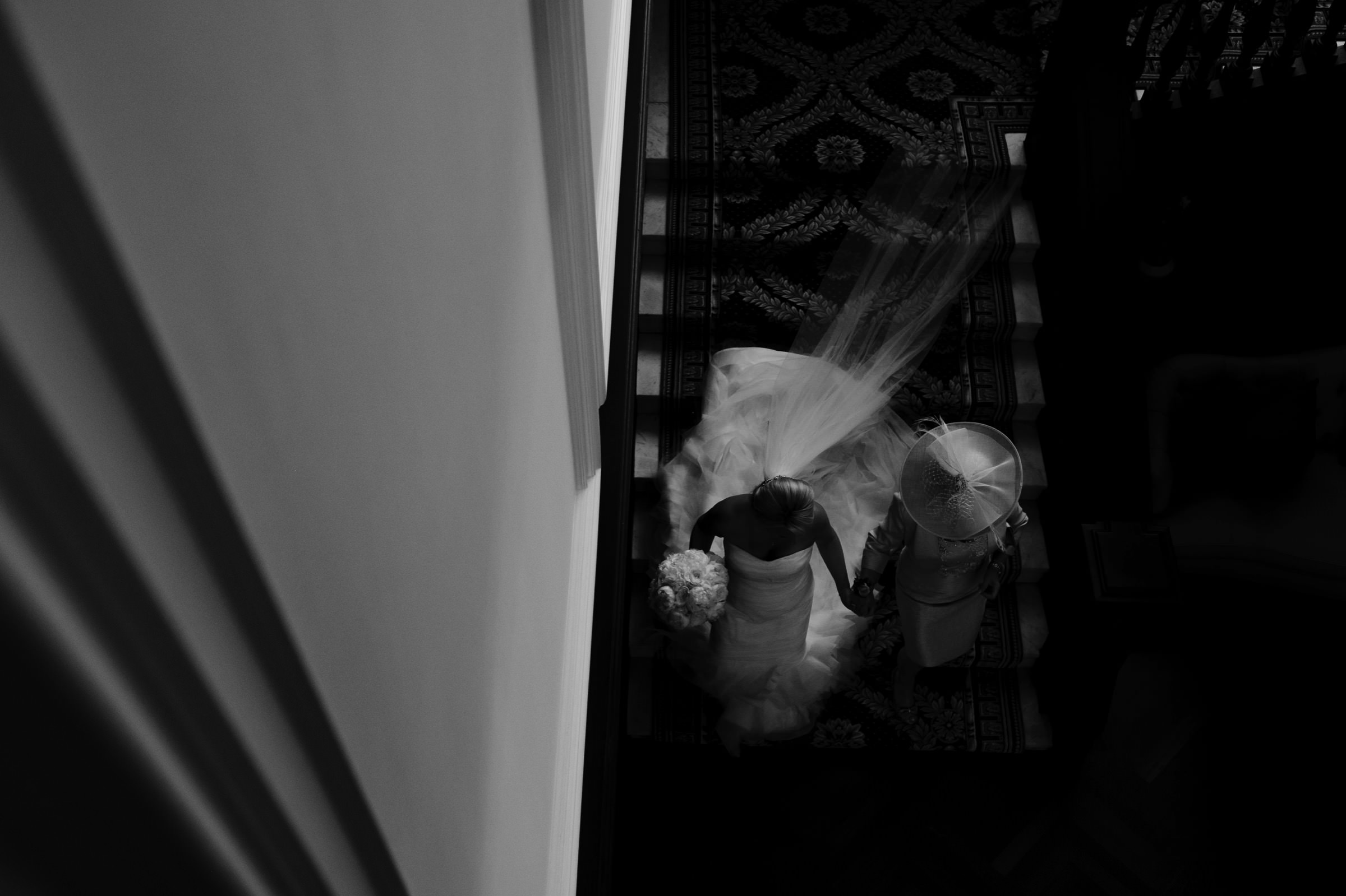 Bride and mother walk down staircase