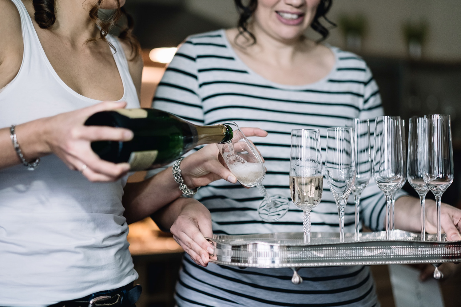 Bridesmaid pouring bride Champagne